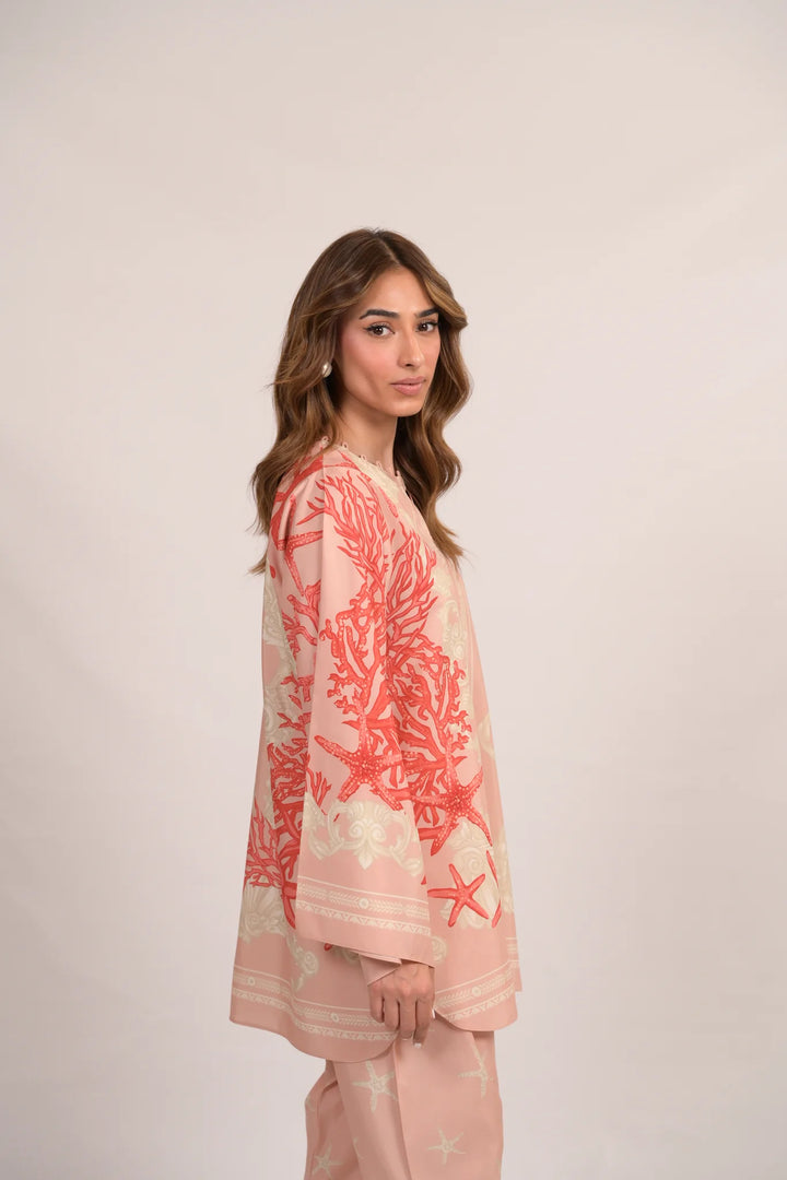 Soft pink cotton-silk co-ord with coral reef-inspired prints—wide-sleeved tunic and matching pants styled in a side pose against a neutral backdrop.