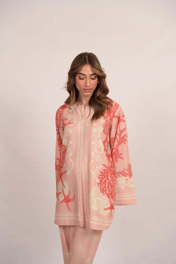 Graceful looks in soft pink cotton-silk—coral and starfish motifs flowing across a relaxed tunic and matching pants, styled with clear heels against a neutral backdrop.