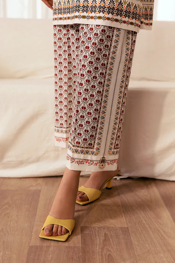 Printed cambric trousers with red and black floral motifs styled with yellow heeled sandals, Pomegranate Blossom, Nainpreet.
