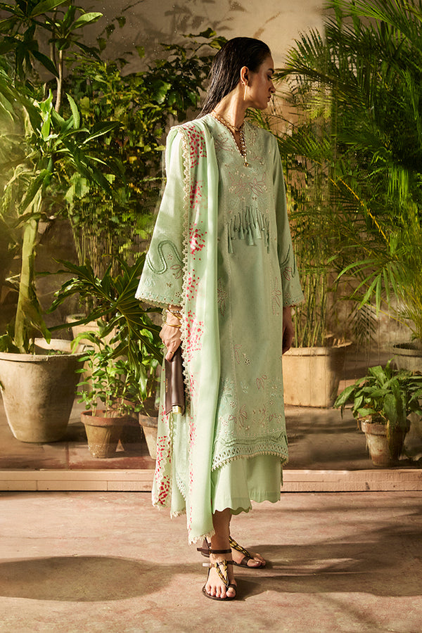 Bathed in garden light, the model wears Nore: a mint green jacquard lawn set with coral embroidery, scalloped culottes, and printed dupatta.