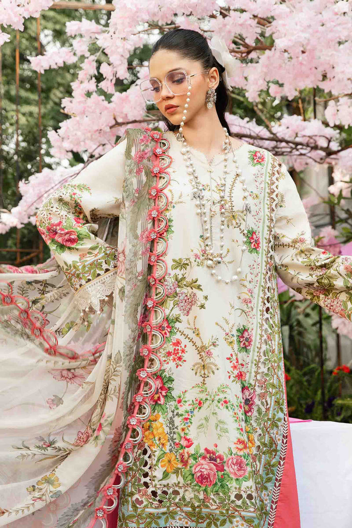 The model stands beneath cherry blossoms in MPT-2605-A — cream-toned florals embroidered across the shirt and dupatta, pearl jewellery and glasses adding a modern touch. Unstitched Mprints ’25 via Nainpreet.
