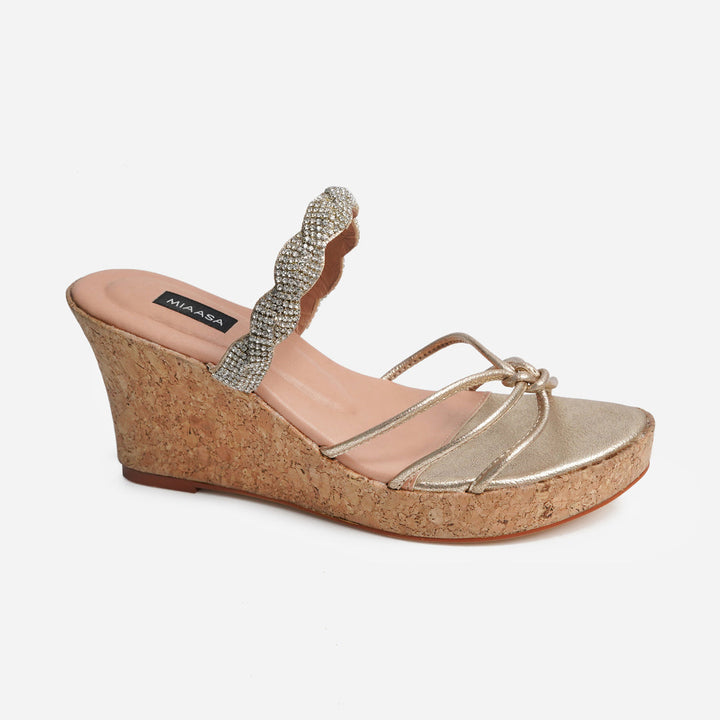 Single Anahita Gold wedge from Soleil Eid ’25: a cork platform sandal with a metallic gold footbed and light pink insole, featuring a toe loop and thin gold straps that converge at the front.