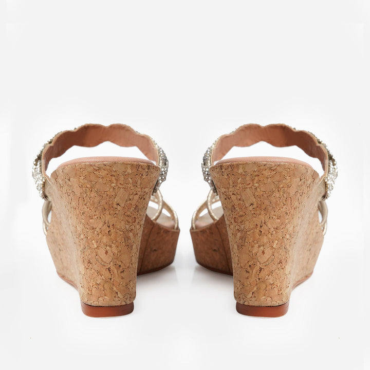 Back view of Anahita Gold wedges from Soleil Eid ’25: cork wedge heels with a gently curved silhouette and open backs featuring scalloped edges.
