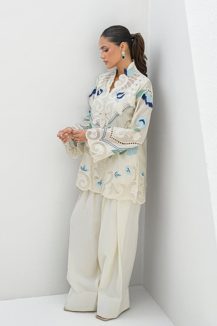 Girl admiring Azure off-white short top with blue embroidered floral from Nadia Farooqui’s Deena Eid Edit '25 collection