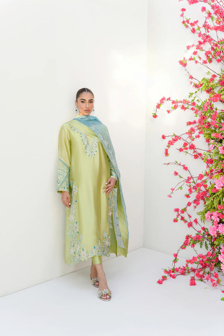 In a full-length view, the model wears Mint Margarita: a lime-kiwi Sheesha silk kurta with intricate embroidery along the sleeves, neckline, and hem, paired with matching trousers and an icy-blue organza dupatta.