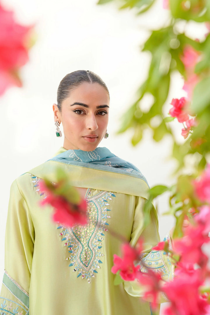 The model wears Mint Margarita: a lime-kiwi Sheesha silk shirt with intricate embroidery around the neckline and sleeves, paired with a light blue organza dupatta featuring matching detailing.