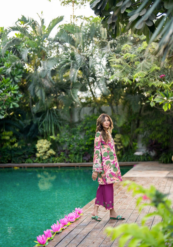 Girl in Solids Official Amalfi pink-green floral kurti, purple shalwar, green sandals by pool. A Summer Weekend '25 collection. Ideal for Indian summers.