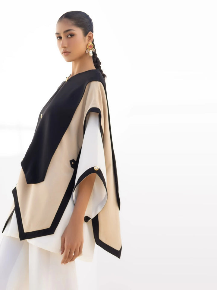 Model showcases Iqa Raya: an ivory-colored top over white kurti & wide-leg pants. Nyra '24, for chic Indian contemporary fashion.
