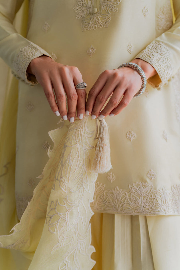 Close-up view on the details of Lime Zest — butter-lime raw silk embroidered in soft white florals, tasselled dupatta held with manicured grace. Eid Ul Adha ’25 via Nainpreet.
